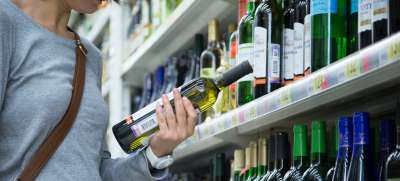 Женщина выбирает алкогольные напитки в супермаркете Москвы, Россия. Фото ВОЗ/Сергей Волков