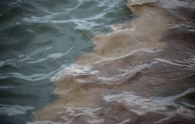 Дизельное топливо в воде на месте ликвидации последствий разлива топлива на ТЭЦ-3. Фото Кирилл Кухмарь/ТАСС