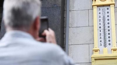 Мужчина фотографирует термометр на здании Государственной думы России в Москве. Архивное фото РИА Новости / Илья Питалев.