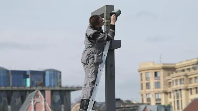 Рабочий протирает камеру видеонаблюдения в центре Москвы. Архивное фото РИА Новости / Алексей Никольский