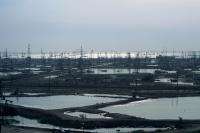 Буровые вышки и следы нефтяного загрязнения на берегу Каспийского моря в Баку, Азербайджан