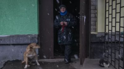 Женщина выходит из подъезда жилого дома в освобожденном городе Счастье в Луганской народной республике. Фото: РИА Новости / Валерий Мельников.