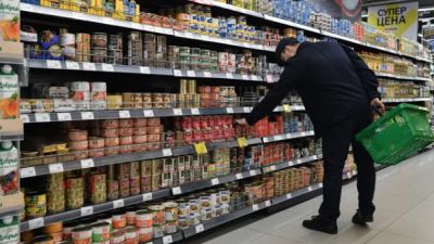 Покупатель выбирает консервы в одном из супермаркетов . Архивное фото РИА Новости / Рамиль Ситдиков.