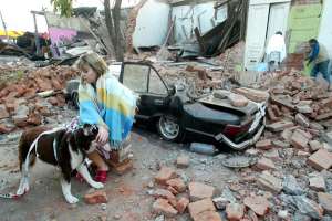 Женщина перед разрушенными домами в г. Талька. Землетрясение в Чили. Фото: http://www.etoday.ru