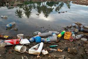 Пластиковые бутылки и мусор из соседней деревни вымываются на берега реки, а потом попадают в море. Фото ООН/Мартин Перре